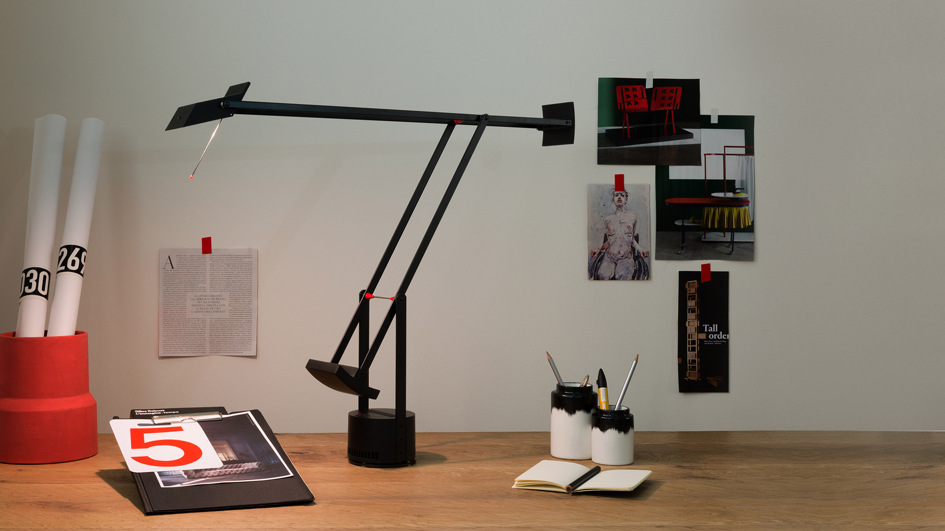 Artemide Tizio Classic in black with counterweights and head rod, extended over a wooden desk